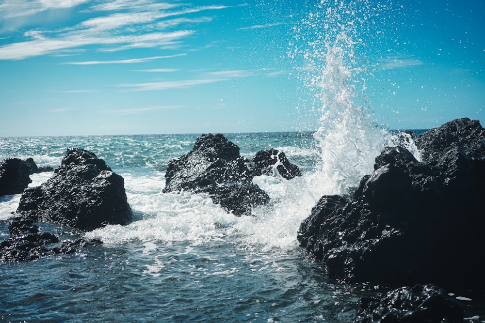 a wave hitting on rocks in the ocean