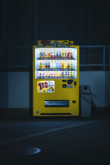 A sleek, modern vending machine glowing with electric green accents in a stylish Las Vegas office breakroom.