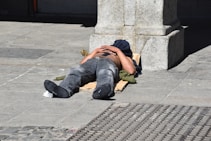a man laying on the ground with his head on his hands