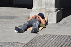 a man laying on the ground with his head on his hands
