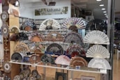 A variety of fans displayed neatly on shelves in a well-lit store.