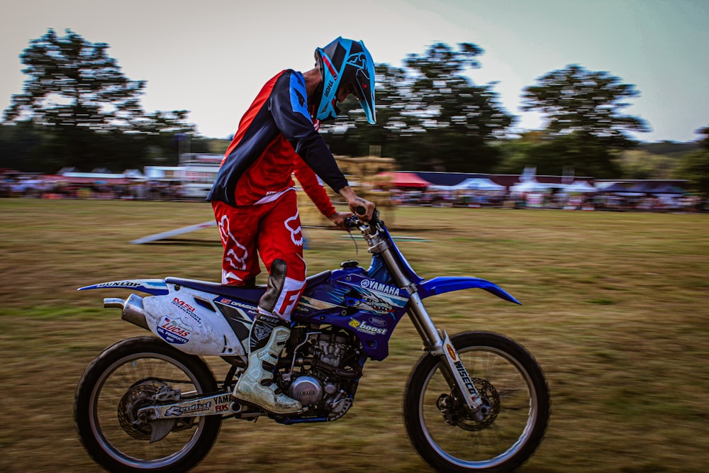 a man riding a dirt bike on top of a grass covered field