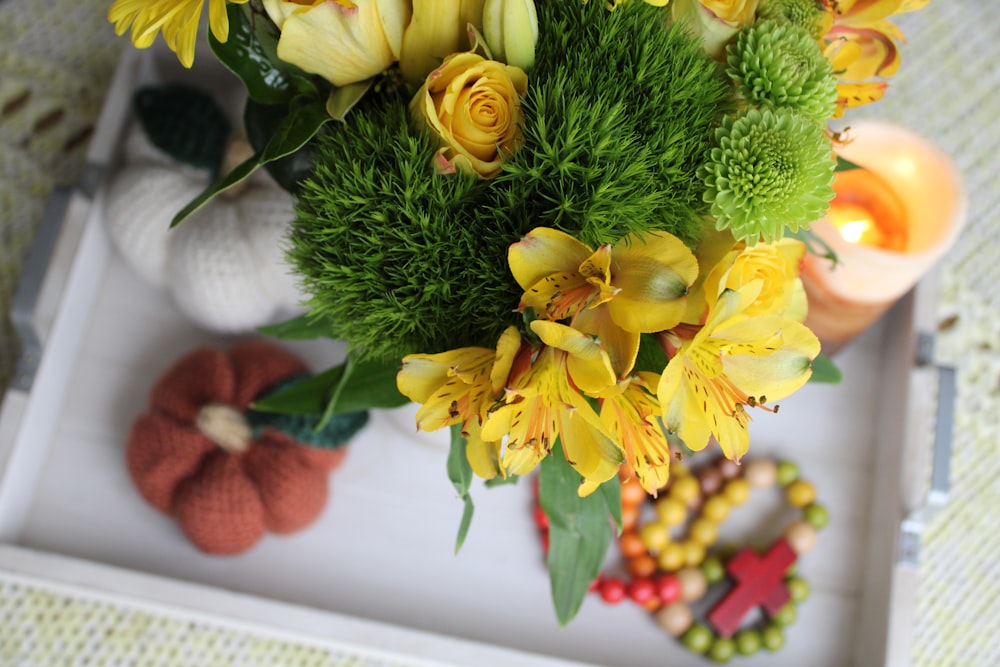 a bouquet of yellow flowers sitting on top of a white tray