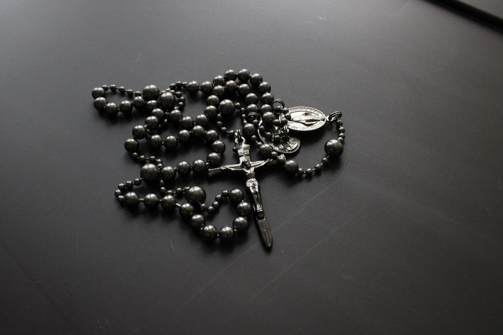 a rosary is laying on a black surface