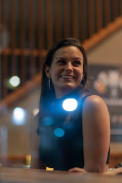 Portrait of Gabriela Pérez smiling warmly in a softly lit, elegant workspace with feminine and modern decor.