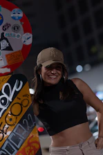 Vibrant photo of a Black woman smiling confidently in colorful streetwear, urban background full of graffiti.