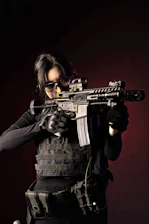 Individual loading a shotgun with focus and safety gear on