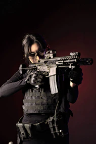 A focused instructor guiding a student through firearm handling on a dark, tactical training range.