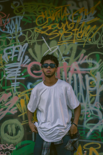 Close-up of a vibrant oversized streetwear t-shirt draped casually on a graffiti-covered wall.