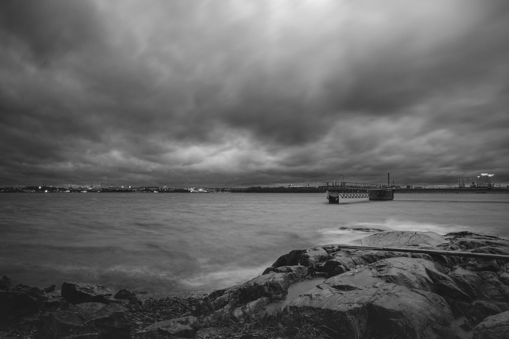uma foto em preto e branco de um céu nublado sobre um corpo de água