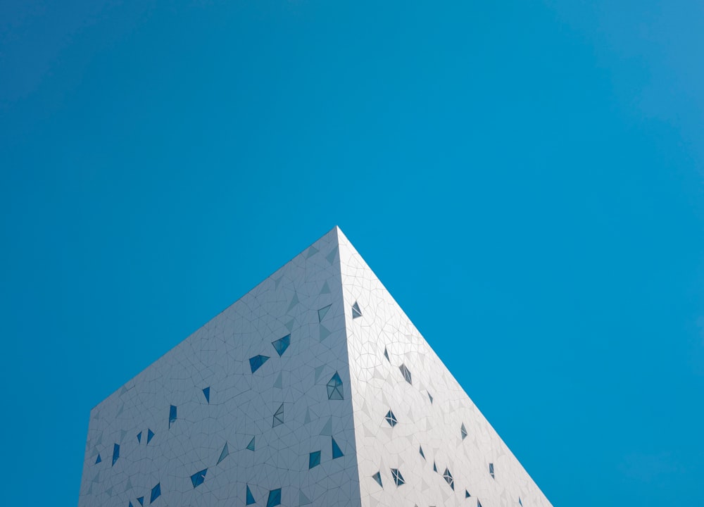 a tall white building with a blue sky in the background