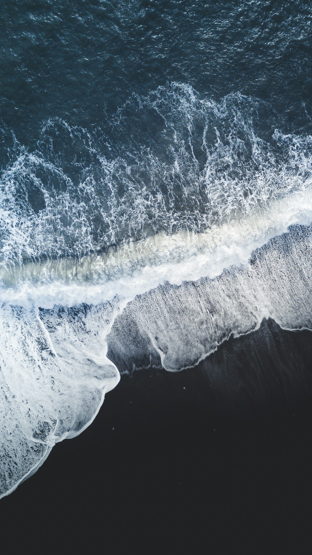 an aerial view of the ocean with waves