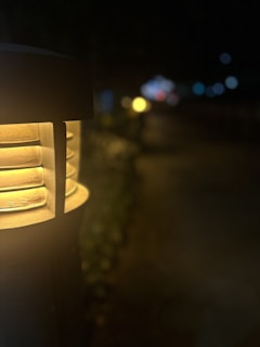 Close-up of a street lamp glowing softly in the evening, photographed with tactile emphasis.