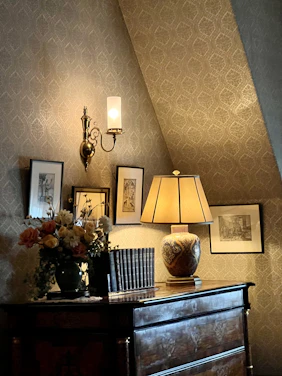 A softly lit, elegant apartment corner decorated with muted tones and tasteful vintage-inspired accents.