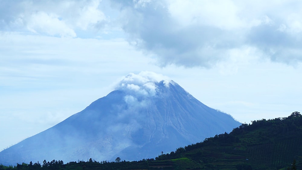 a very tall mountain with a cloud in the sky