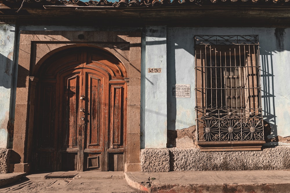 a blue building with a wooden door and window