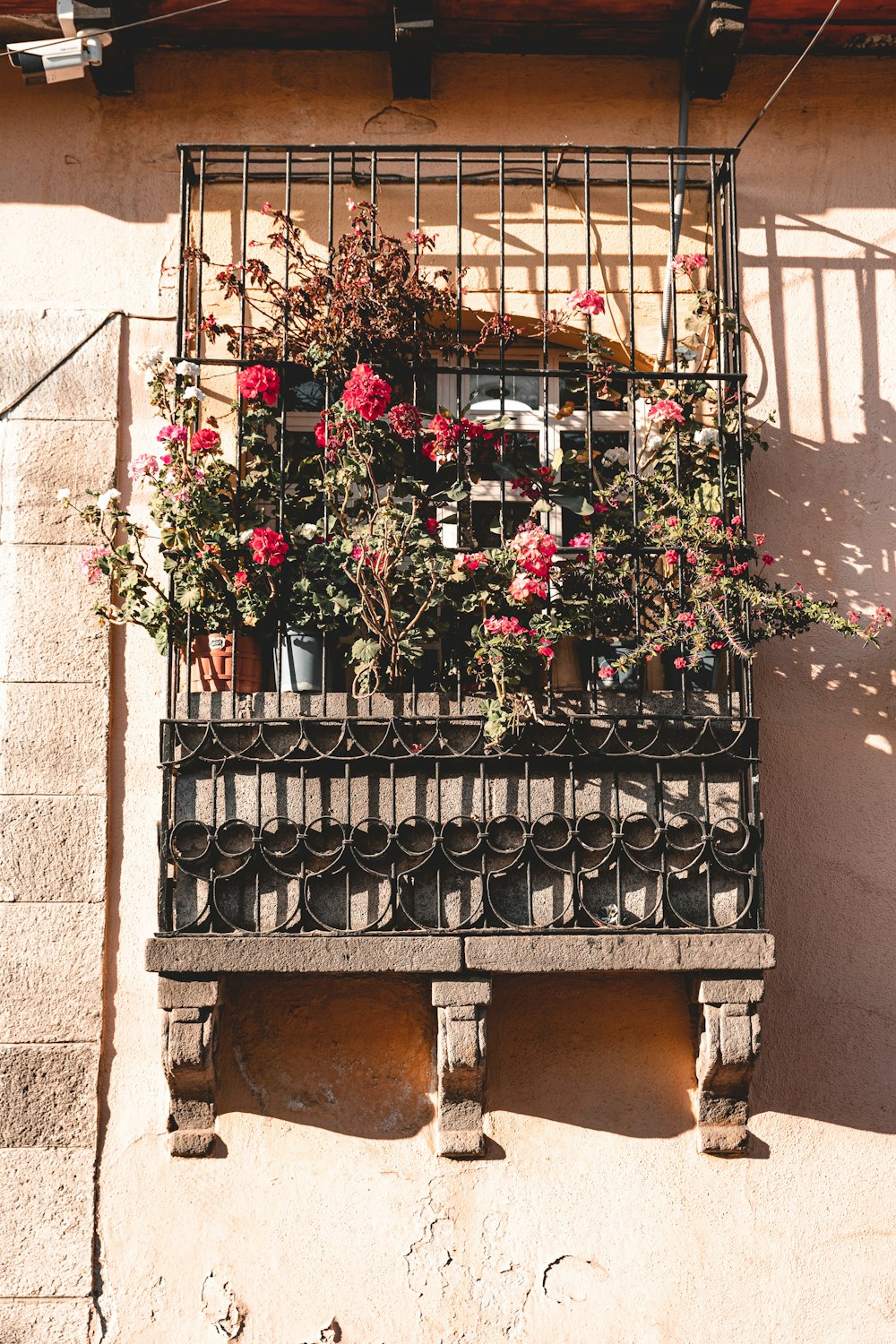 a wrought iron window box with flowers in it