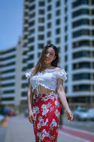A chic outfit set featuring a matching top and skirt in vibrant colors, styled on a young woman outdoors.