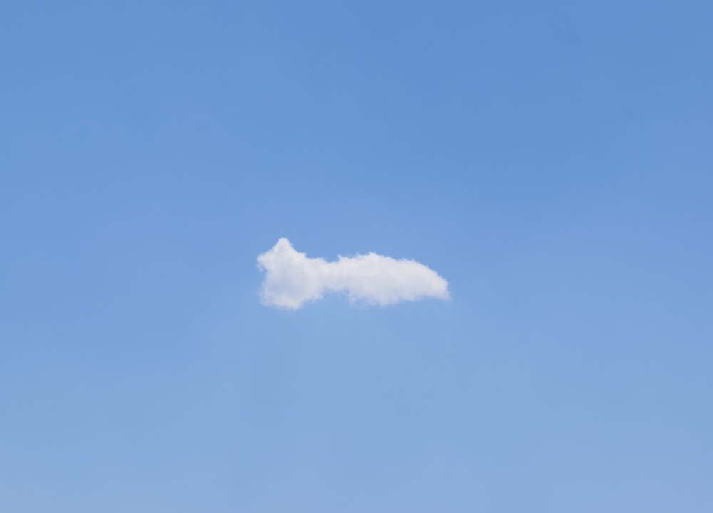 a white cloud floating in a blue sky