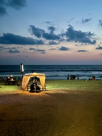 A serene beach at sunset with a luxury cabana set for two.