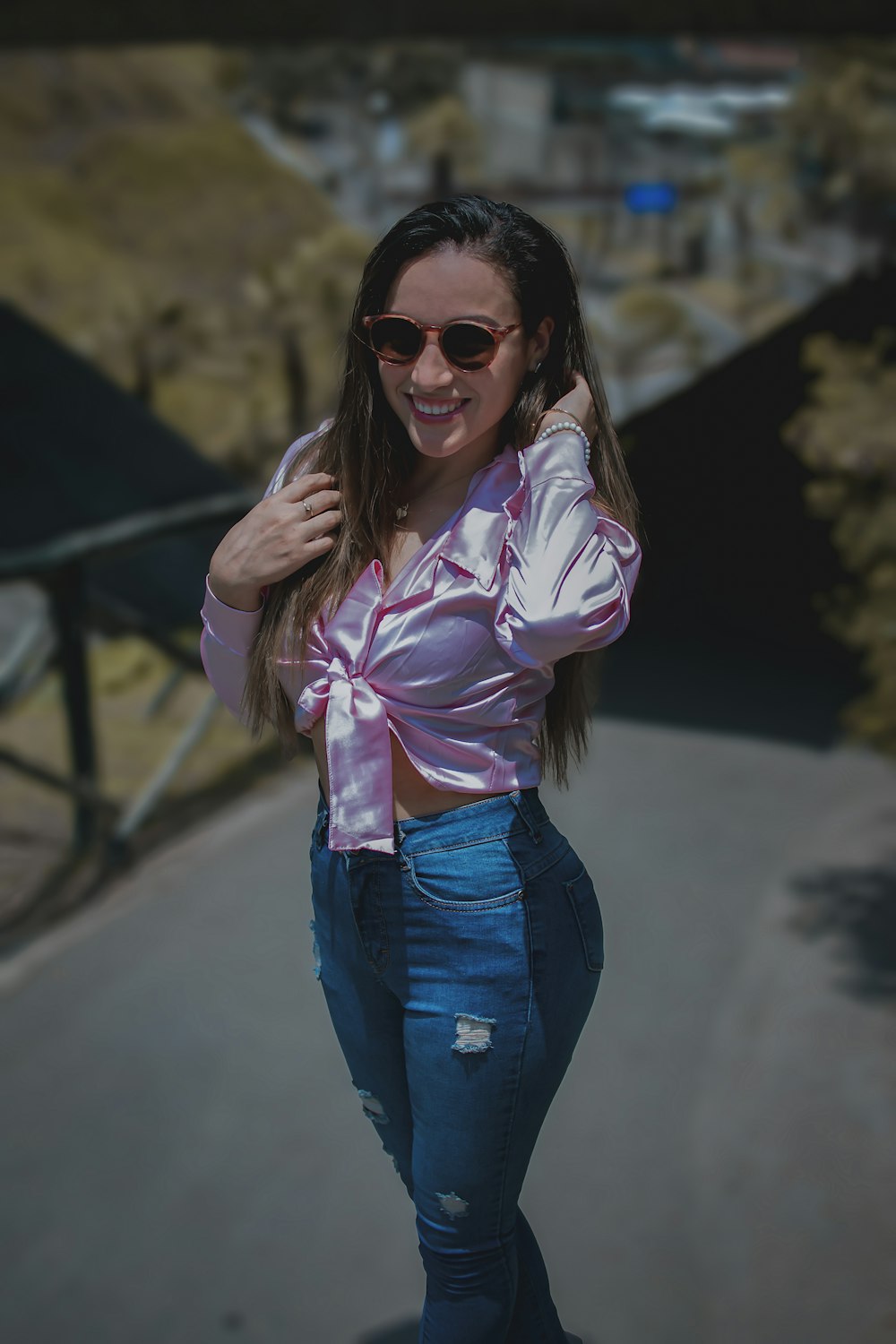 a woman in a pink shirt and jeans posing for a picture