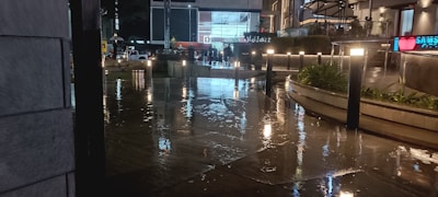 A vibrant commercial plaza illuminated at night with people enjoying the atmosphere.