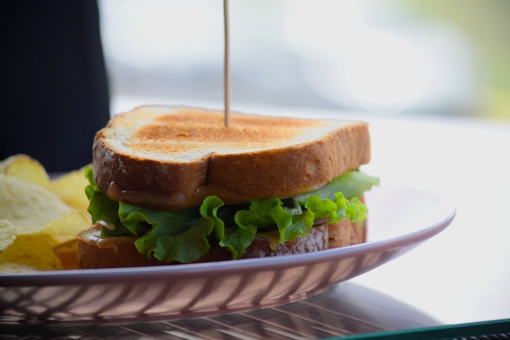 a sandwich with lettuce and cheese on a plate