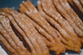 A close-up of several churros arranged next to each other, with a dusting of sugar visible on their surfaces. The fried dough has a golden brown color, and the texture looks crispy.
