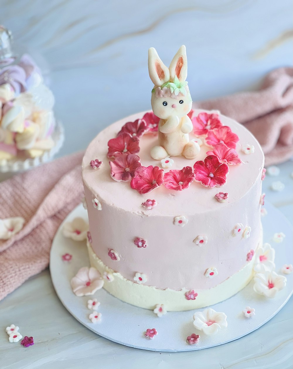 a pink cake with a bunny figurine on top of it
