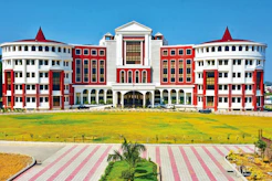 a large red and white building sitting on top of a lush green field