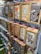 A display rack featuring iPhone cases decorated with various colorful and artistic designs. These designs include traditional Okinawan themes and motifs, such as Shisa (guardian lion dogs) and other local imagery. The cases are packaged in cardboard boxes, each with visible branding and labels related to Okinawa.