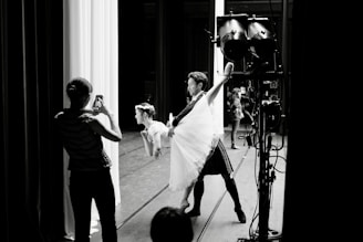Dynamic photo of Frank David López directing dancers on stage during a rehearsal.
