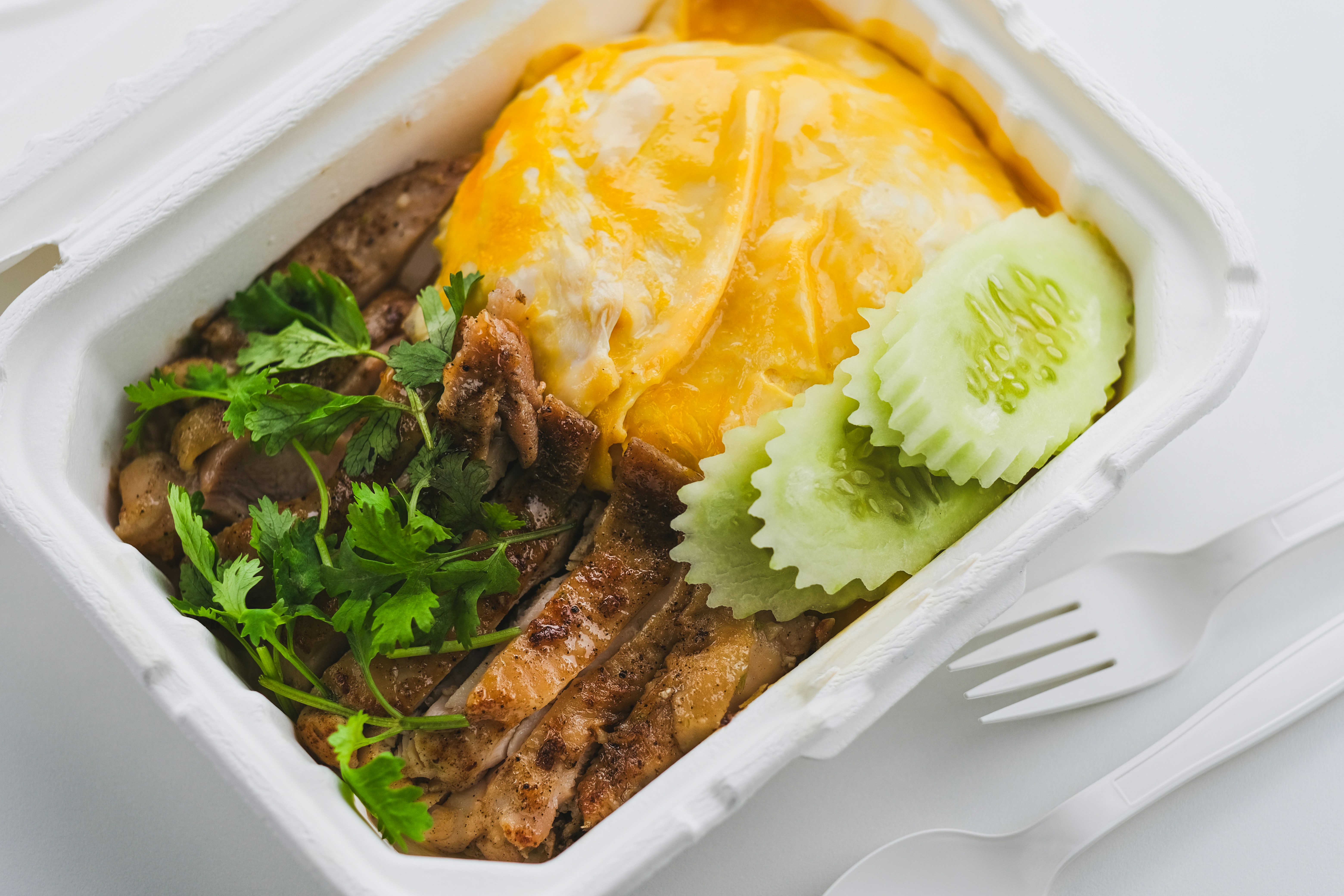 a plastic container filled with meat and vegetables