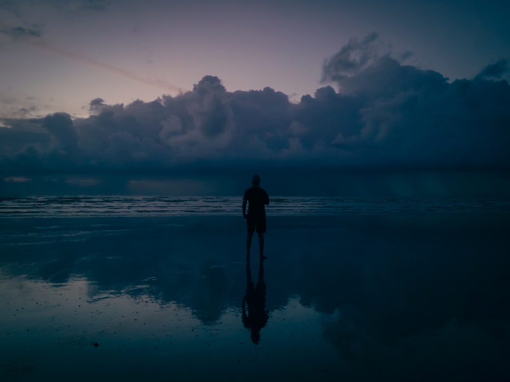 eine Person, die nachts an einem Strand steht