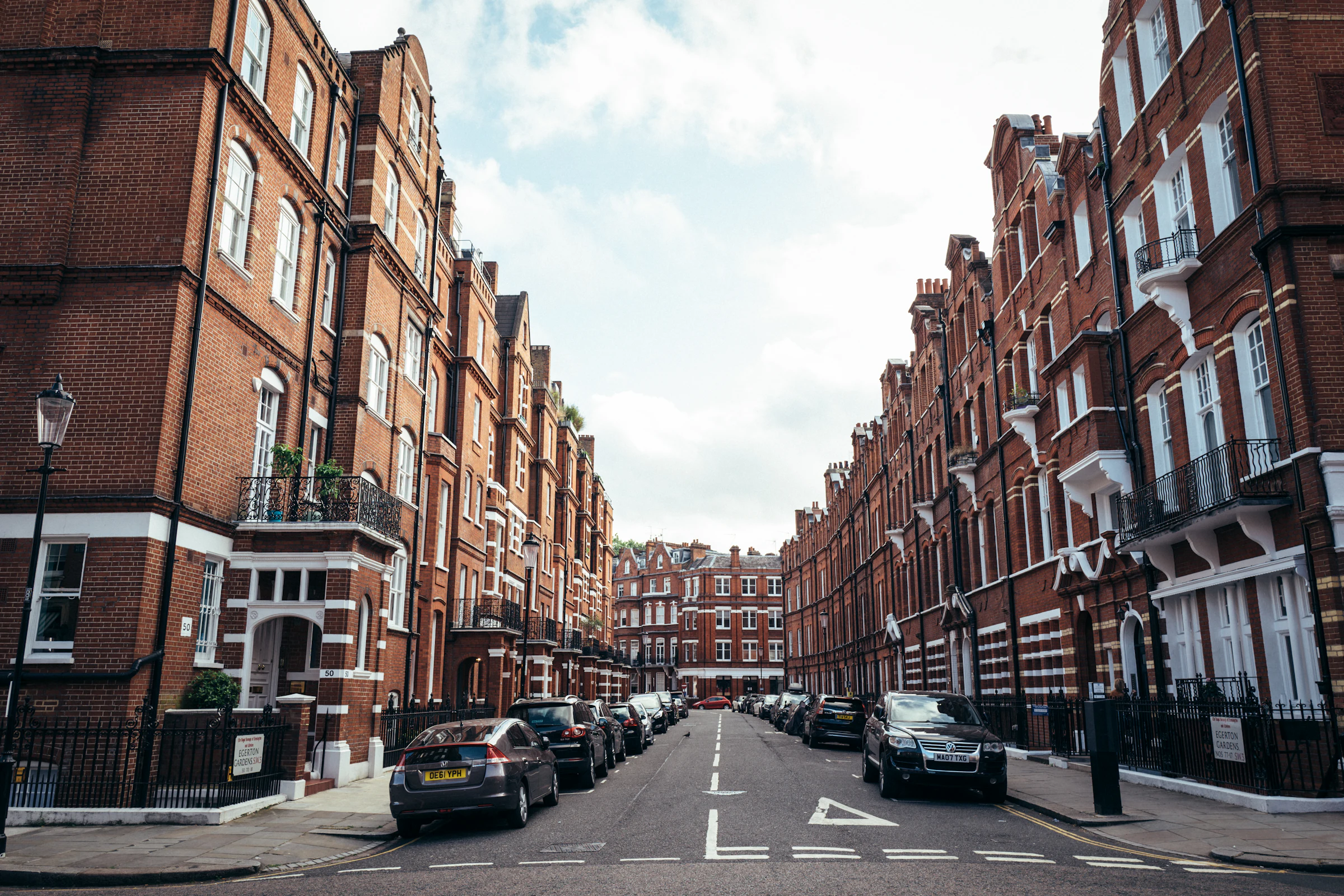 A row of tall brick terraced houses on a London street