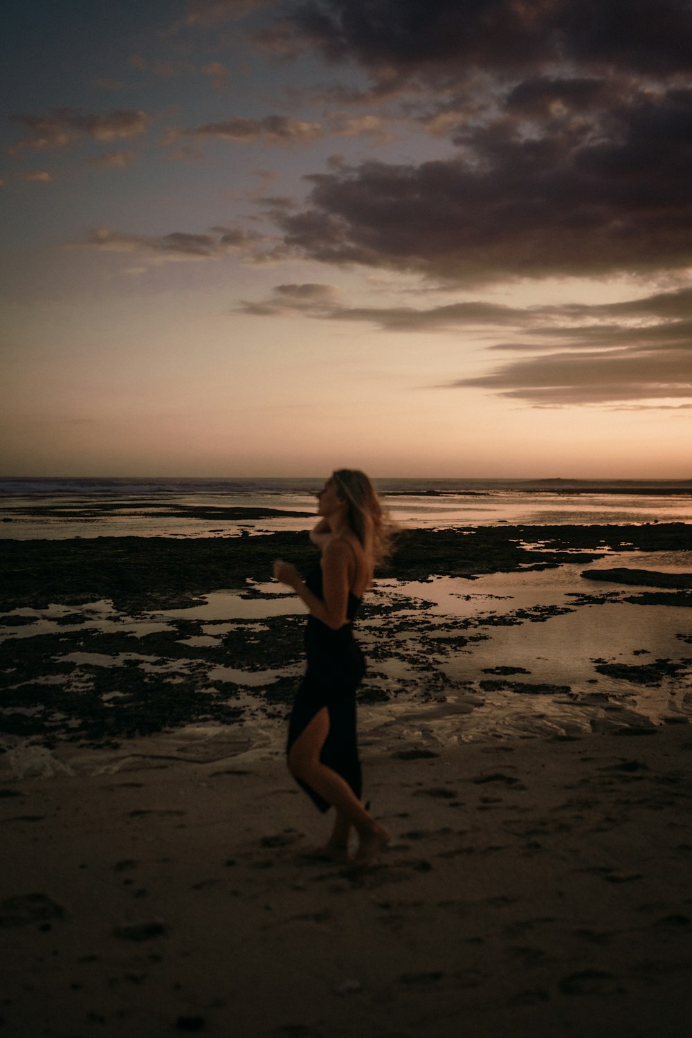 a woman running on the beach at sunset