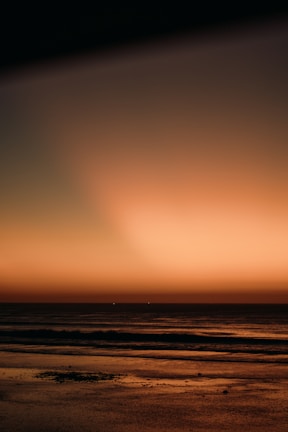 A tranquil sunset over the sea, reflecting warm earth tones.