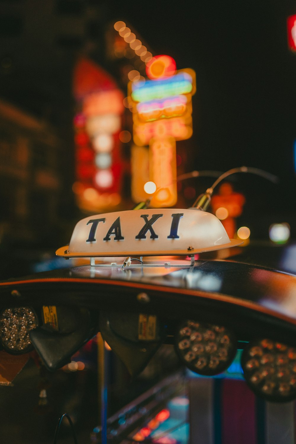 a taxi cab sitting in front of a neon sign
