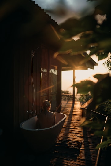 Sunset view of the private wood-fired hot tub glowing warmly beside the cabin deck.