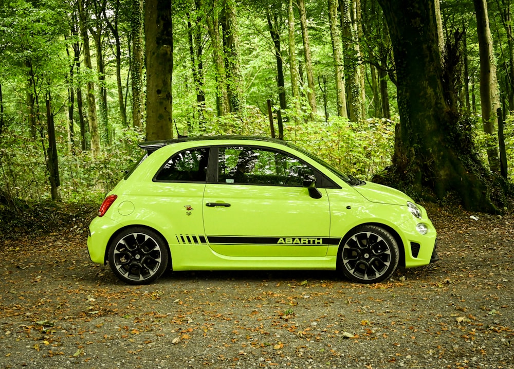 a small yellow car parked in a forest