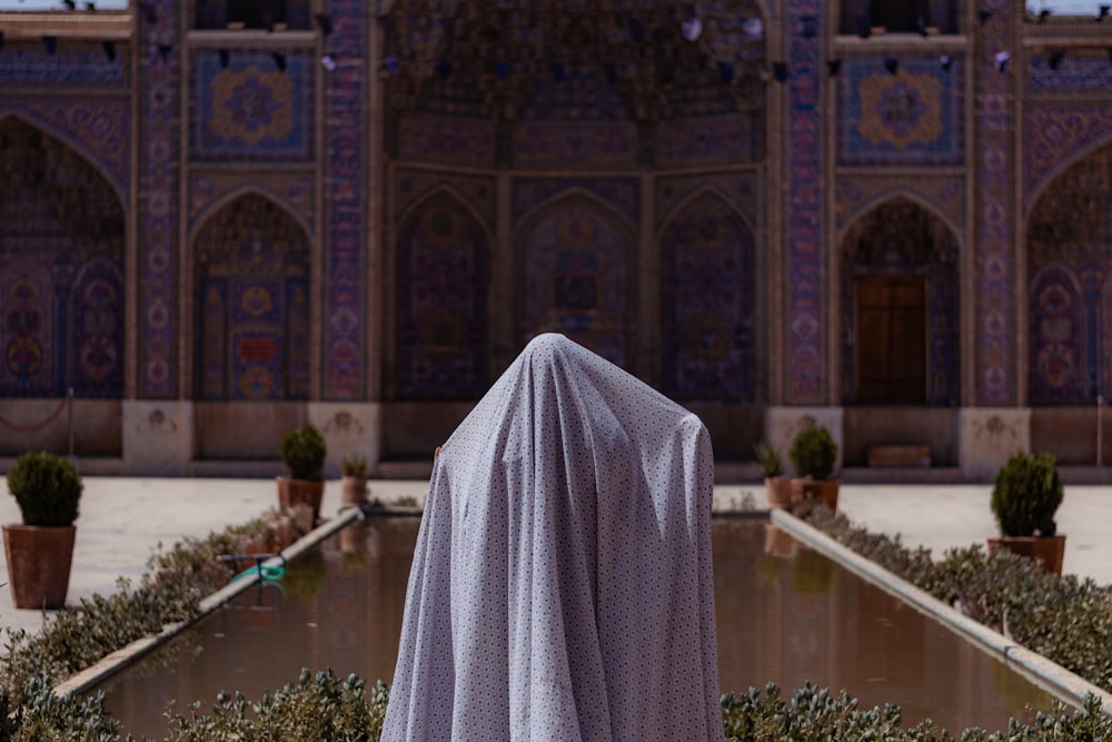 a woman in a veil standing in front of a building