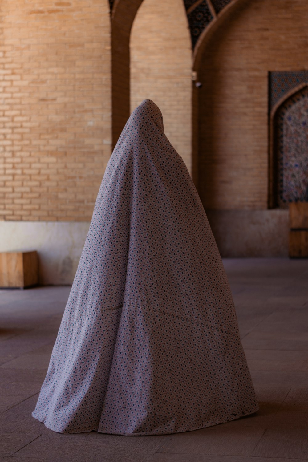 Una mujer envuelta en una manta sentada en el suelo