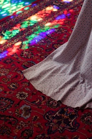 Close-up of a vibrant red carpet with geometric designs, highlighting texture and detail.