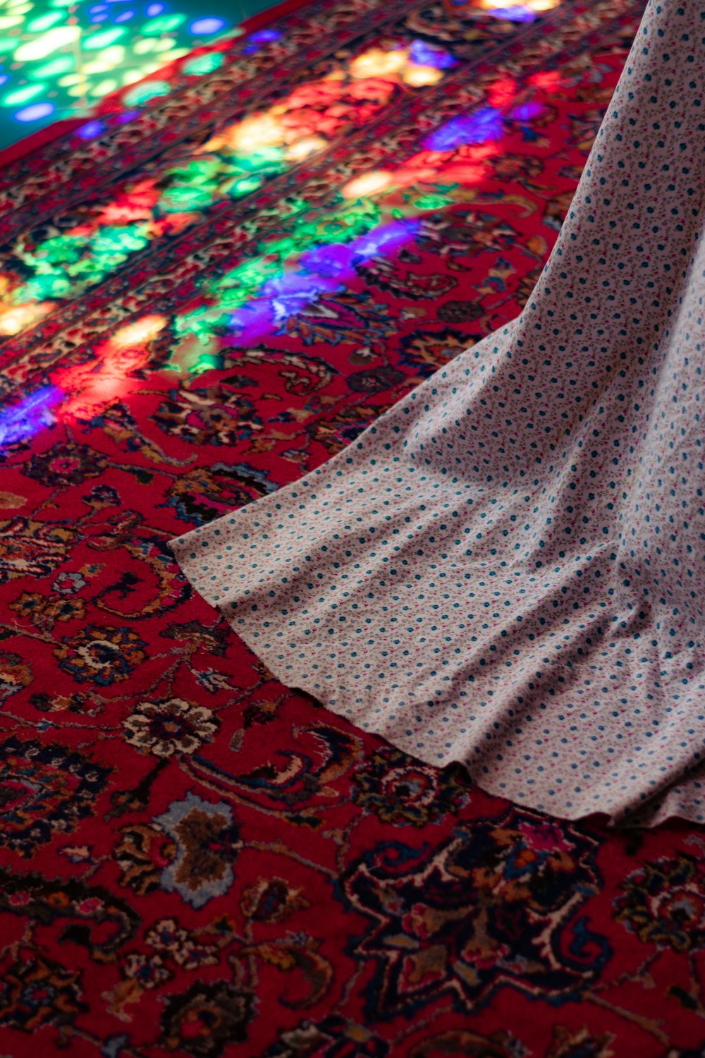 Una persona parada sobre una alfombra frente a una vidriera