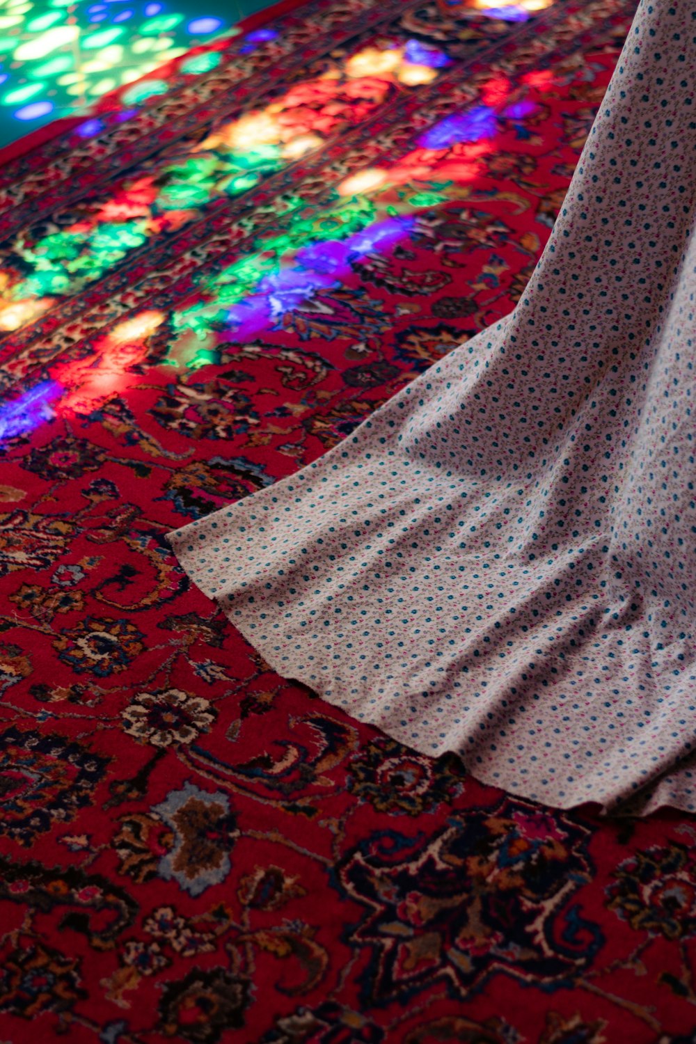 a person standing on a rug in front of a stained glass window