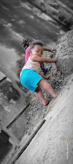 A happy child climbing outdoors, embracing physical challenge with confidence.