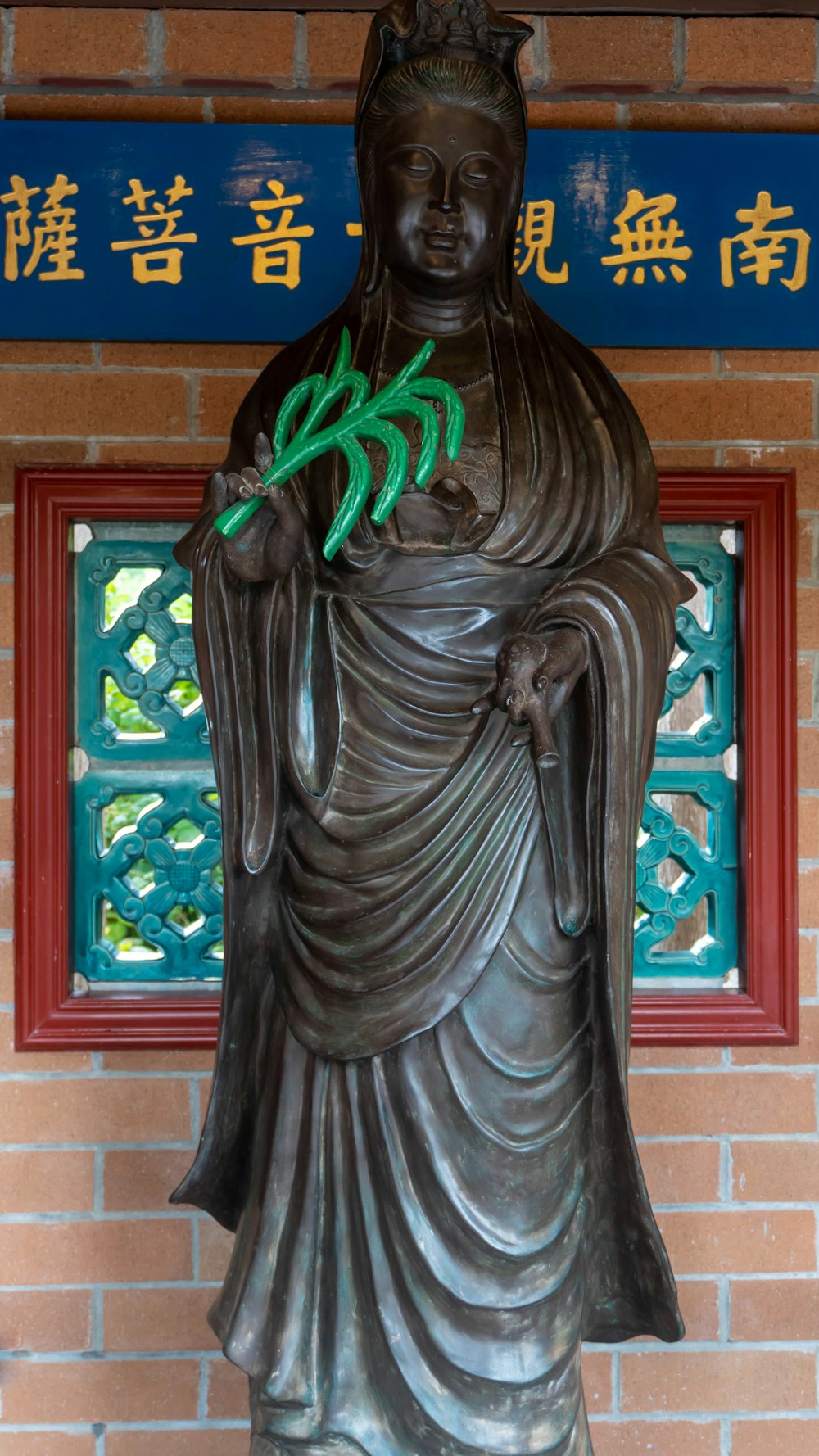 a statue of a person holding a plant