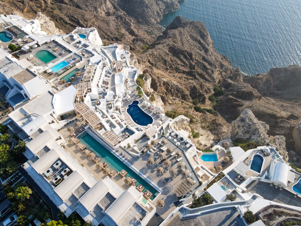 an aerial view of a large white building next to a body of water