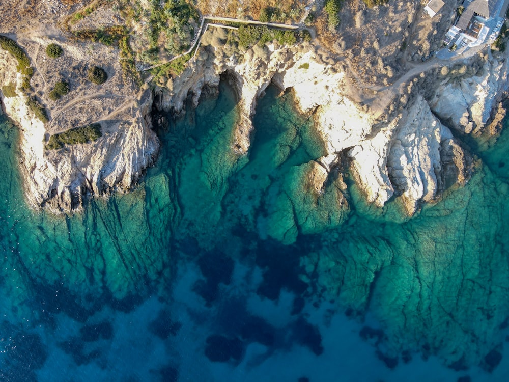 an aerial view of a rocky coastline with clear blue water