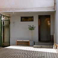 A minimalist garden with sculpted bushes and a small water feature near the entrance.